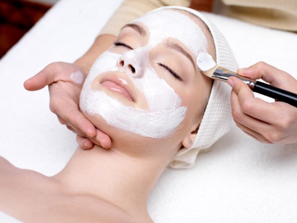 A woman having a customized facial peel applied to her face.