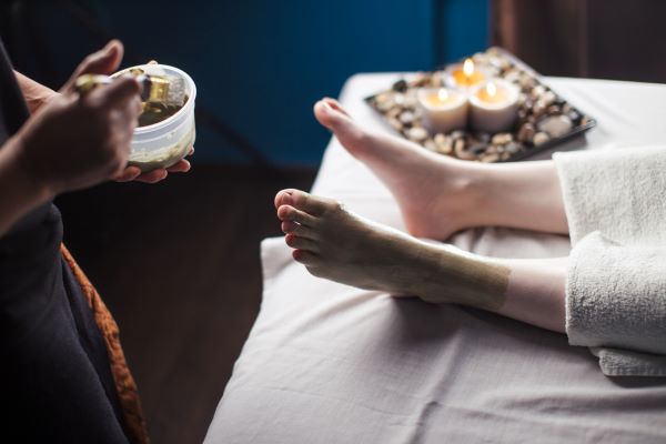 Woman being treated to a foot mask.